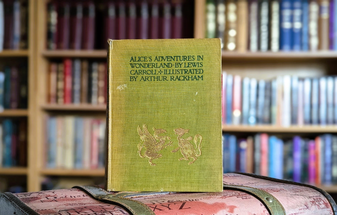 The first edition of Alice's Adventures in Wonderland illustrated by Arthur Rackham standing in front of a bookcase